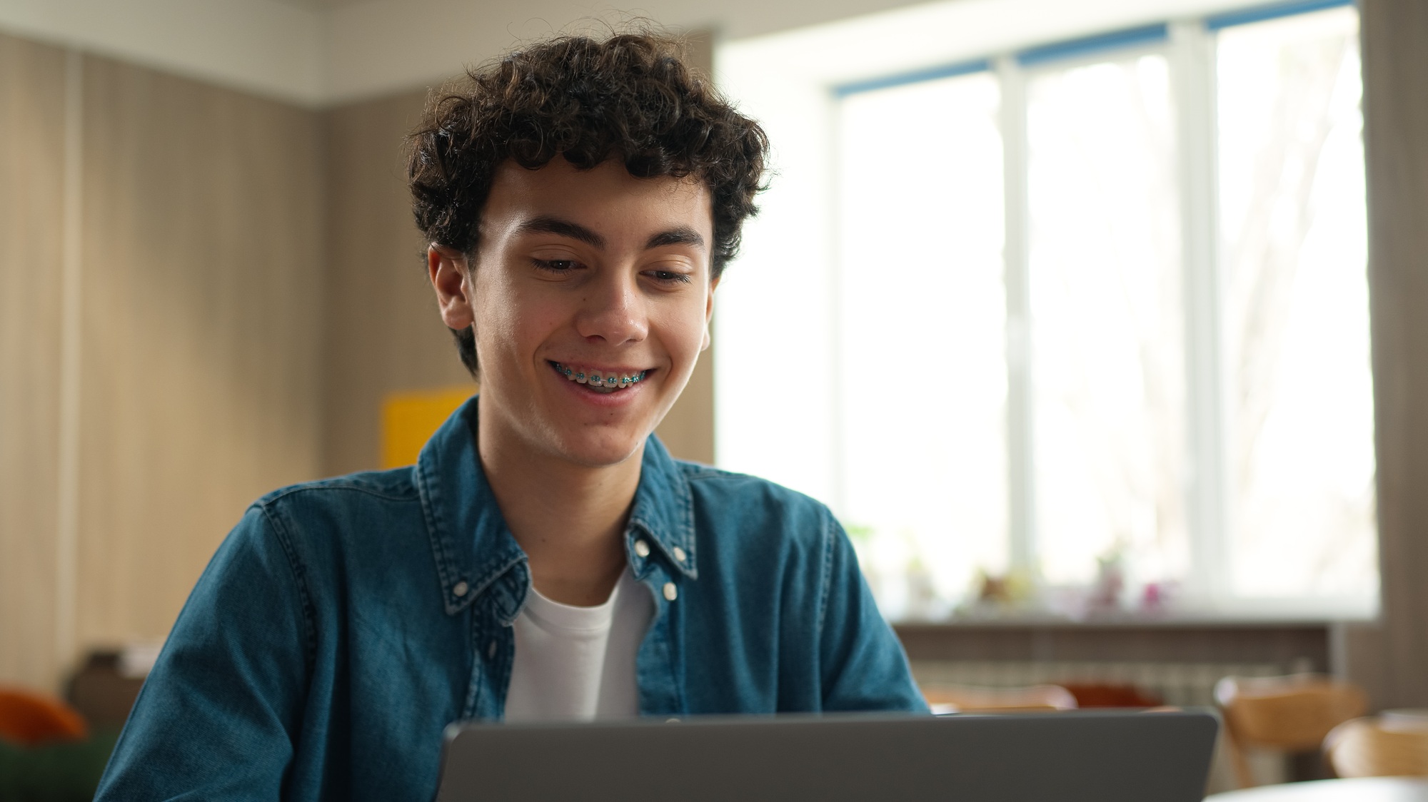 Caucasian man male student guy boy schoolboy pupil with toothy dental braces in class lesson school